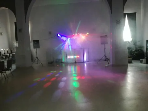 Stanowisko DJ Master na sali z łukami, kolorowe światła odbite w posadzce