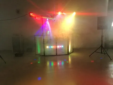 Stanowisko DJ-a w dymie, czerwone i żółte reflektory