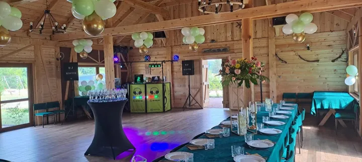 Drewniana sala z balonami i nakrytym stołem, w głębi stanowisko DJ Master z oświetleniem